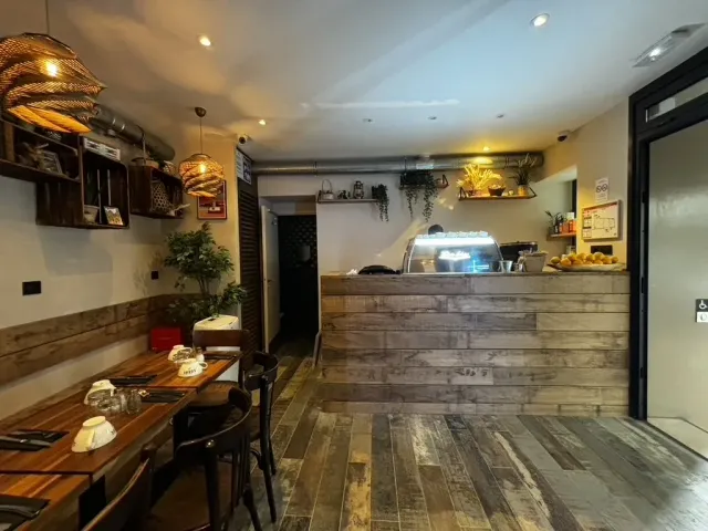Après travaux : comptoir habillé de bois de récupération, vitrine réfrigérée et tables dressées.