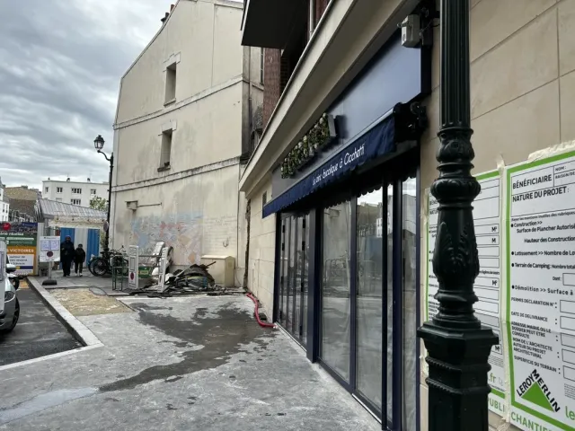Après travaux : la devanture depuis la rue, trottoir repris et panneau de chantier encore en place.