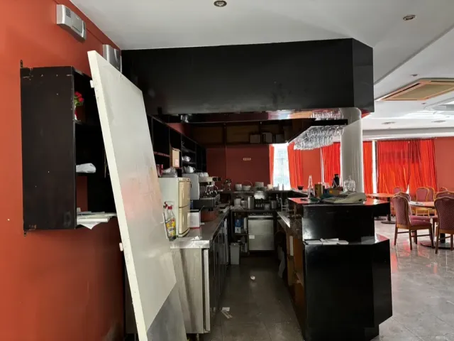 Avant travaux : ancienne salle sombre, bar noir et rideaux rouges.