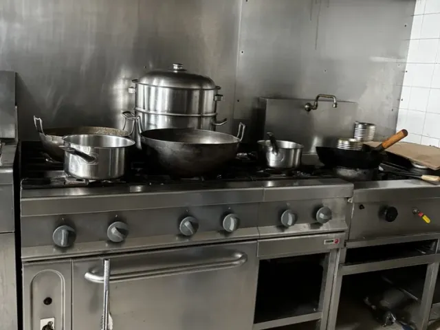 Avant travaux : piano de cuisson existant sous la hotte, crédence inox.