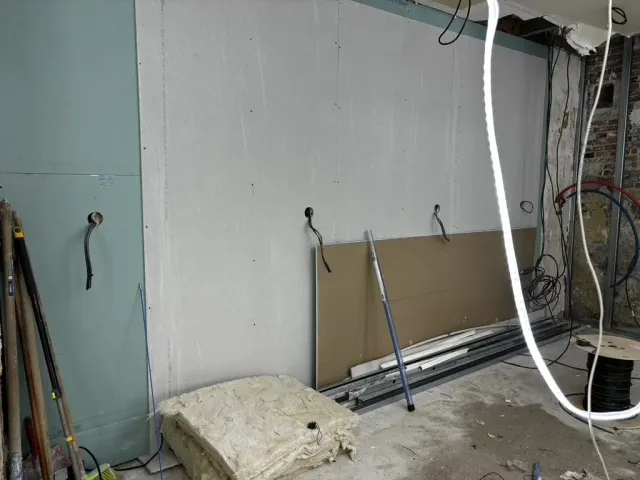 Avant travaux : dépose en cours, réseaux électriques apparents et plaques de doublage en attente.