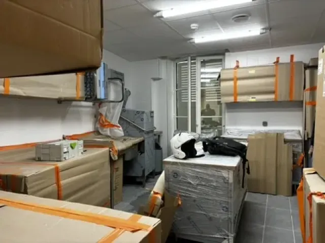 Chantier : matériel de cuisine livré et sanglé, en attente de pose.