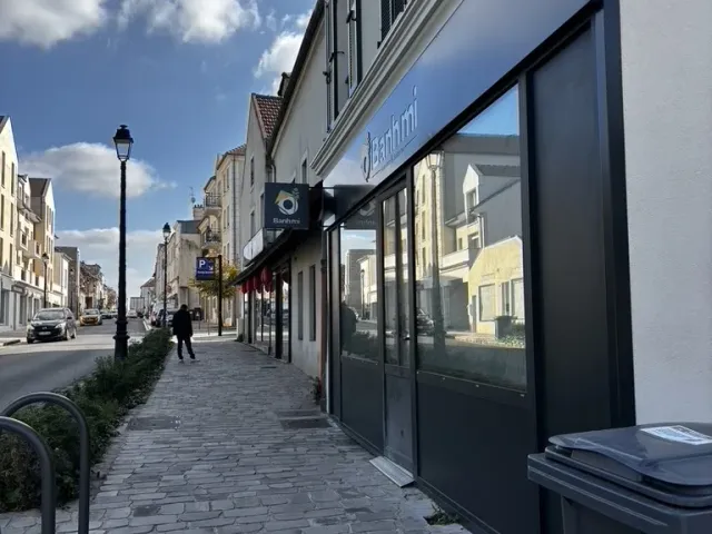 Après travaux : la devanture le long du trottoir pavé, arceaux à vélos posés.