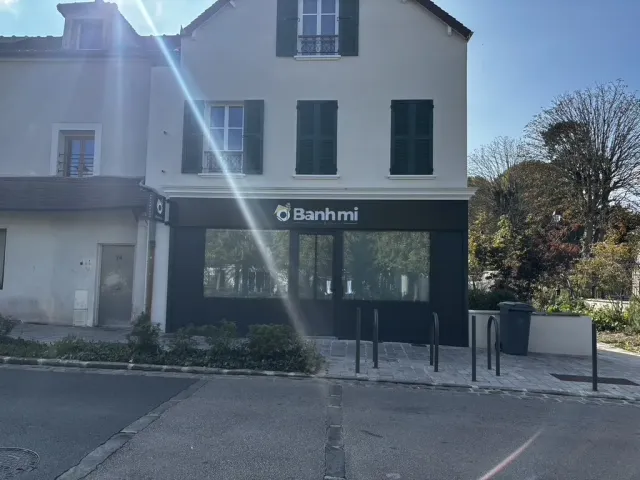 Après travaux : façade livrée, devanture noire toute hauteur et enseigne de l'établissement.