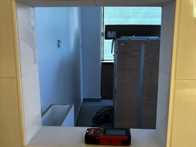 Chantier : passe-plat percé dans la cloison carrelée, ouvrant sur la cuisine.
