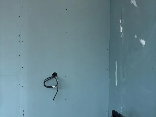 Chantier : cloison en plaques hydrofuges, boîtiers électriques en attente de raccordement.