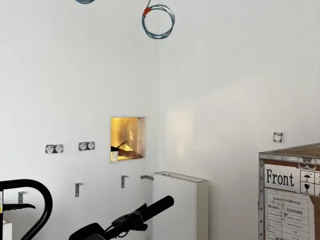 Chantier : réseaux électriques en attente au plafond, équipement encore emballé.